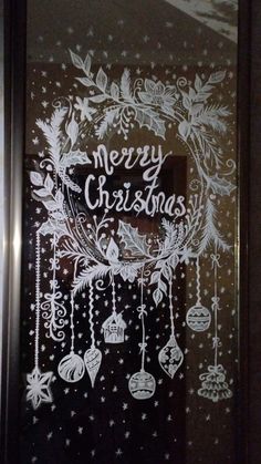 a merry christmas card drawn on the glass door