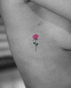 a small pink rose tattoo on the chest