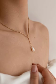 The Marilyn Pearl Necklace is handcrafted with a 14k gold-filled 45cm wheat chain and a single drop pearl dangling from a 1 inch chain (both customizable to your desired length, please leave a note if desired). Packaged in an elegant plastic-free reusable jewelry box, this necklace makes the perfect gift or special treat for oneself.   *14k gold-filled wheat chain *Freshwater drop pearl *Hypoallergenic, suitable for even the most sensitive skin *Delivered in a 100% silk jewelry pouchette inside a gift box *Sustainable magnetic closure jewelry box and customizable card Please note, as we use only natural pearls, shape and size may vary slightly.  We offer a one year guarantee from the date of delivery. Cheap Pearl Chain Necklace Gift, Wedding Hair Pearls, Simple Pearl Necklace, Single Pearl Necklace, Silk Jewelry, Pretty Jewelry Necklaces, Pearl Necklace Wedding, Jewellery Business, Dream Day