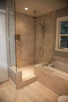 a bathroom with a walk in shower next to a bath tub