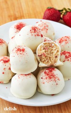 white chocolate covered with red sprinkles on a plate next to strawberries