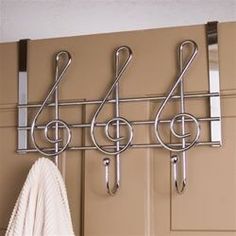 a coat rack with three hooks and two coats hanging on it