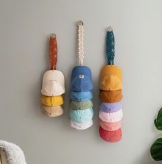 four hats hanging on the wall in different colors