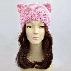 a mannequin head wearing a pink knitted hat with cat ears on it