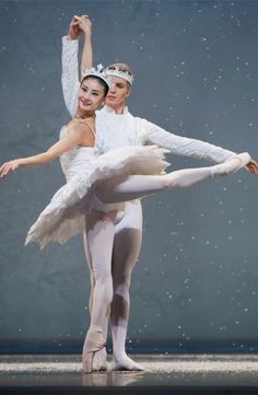 two ballerinas dressed in white pose for the camera