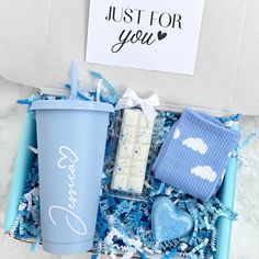 a blue gift box filled with personalized items and a note that says just for you