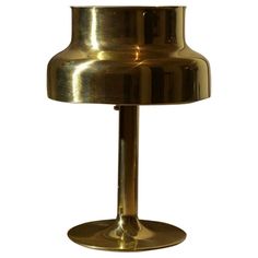 a gold colored table lamp on a white background with clippings to the bottom