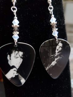 a pair of black and white photos are hanging from earrings