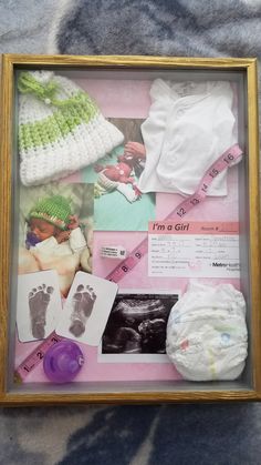 a baby's hand and foot prints are displayed in a wooden frame on a blanket