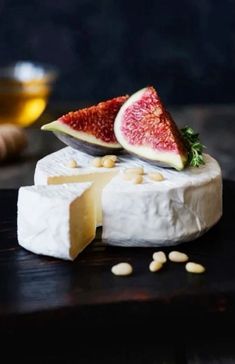 two pieces of cheese with figurines and nuts on the table next to them