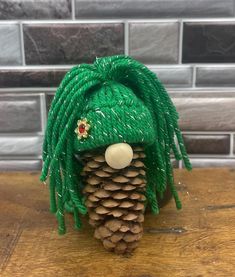 a pine cone with green dreadlocks on it