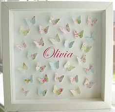 a white frame filled with butterflies on top of a window sill