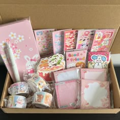 a box filled with lots of different types of stationery and wrapping paper on top of a table