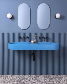 a blue sink in front of two mirrors on the wall and another mirror above it