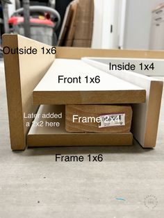 an open cardboard box sitting on top of a floor next to a frame with measurements