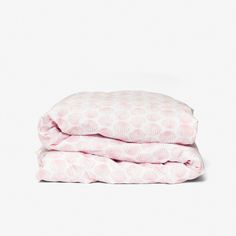 two sheets folded on top of each other in pink and white print, with the covers pulled down