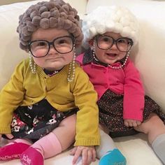 two small children sitting next to each other on top of a white couch wearing glasses