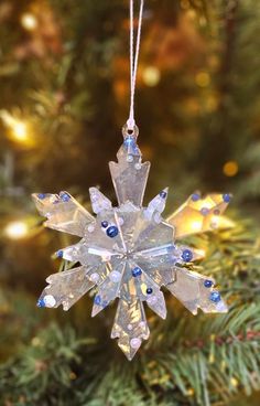 a snowflake ornament hanging from a christmas tree