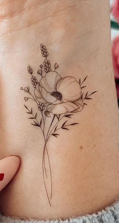 a woman's stomach with a flower tattoo on it