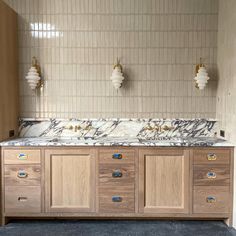 a bathroom with marble counter tops and wooden cabinets