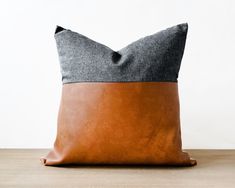 a brown and grey pillow sitting on top of a wooden table