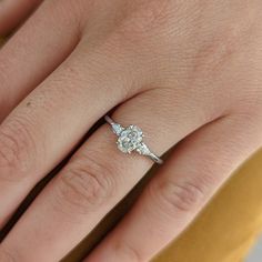 a woman's hand with a diamond ring on it