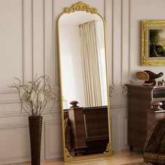 a large mirror sitting on top of a wooden floor next to a dresser and chair