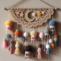 a crocheted wall hanging with tassels, beads and other items attached to it