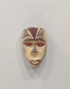 a wooden mask hanging on the wall