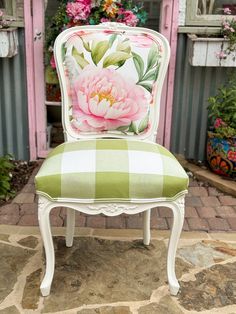 a white chair with a pink flower on the back and green checkered seat cushion