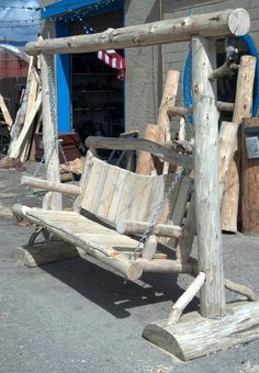 a wooden swing sitting in front of a building