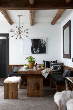 a dining room table and bench in front of a painting on the wall above it