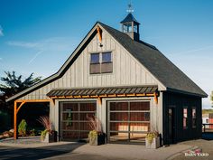 a two car garage with a steeple on the top and an open front door