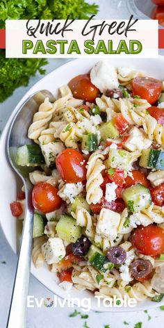 pasta salad with tomatoes, cucumbers and feta cheese in a white bowl