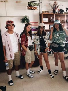 four young people standing in front of a book shelf