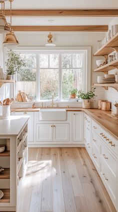 a kitchen with white cabinets and wood floors is seen in this image from the inside