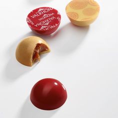 three different types of candies on a white surface, one is red and the other is yellow