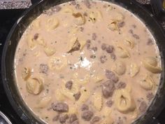 a pan filled with pasta and meat on top of a stove