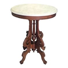 a marble topped table with wooden carvings on the top and bottom, against a white background