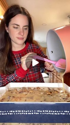 a woman is mixing food in a pan with a pink spatula on top of it