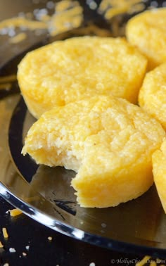 some fried food on a black plate with yellow sprinkles around the edges