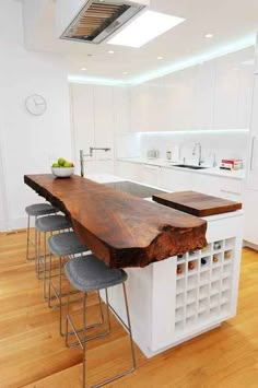 a kitchen with an island made out of wood and metal barstools in the center