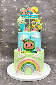 a birthday cake decorated with an animal and rainbow theme