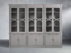 a gray bookcase with glass doors and drawers on the front, against a white background