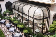 an aerial view of a restaurant with tables and chairs in the courtyard, surrounded by greenery