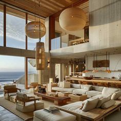 a living room filled with lots of furniture next to an ocean side house near the beach