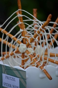 pretzel spider webs are wrapped in white chocolate and sprinkled with icing