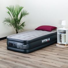 an inflatable bed sitting on top of a wooden floor next to a book shelf