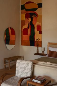 a bed room with a neatly made bed and paintings on the wall