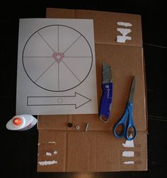 a cardboard box with scissors, tape and other crafting supplies sitting on top of it